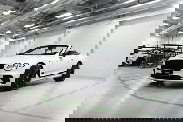 Vista lateral del Bentley Continental GT Convertible en una instalación industrial.