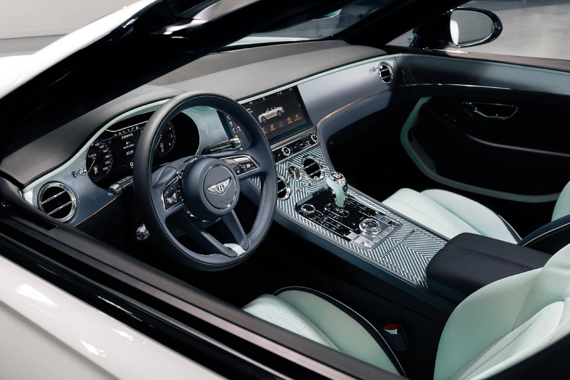 Vista lateral del lujoso interior del Bentley Continental GTC, destacando su elegancia y tecnología.