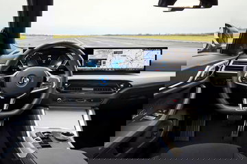 Cabina del BMW i4 eDrive mostrando volante, pantallas y consola central.