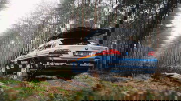 Vista trasera del BMW Serie 7 4x4 preparado para rally en un entorno boscoso