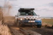 BMW Serie 7 modificado para terreno 4x4 en acción por un camino rural