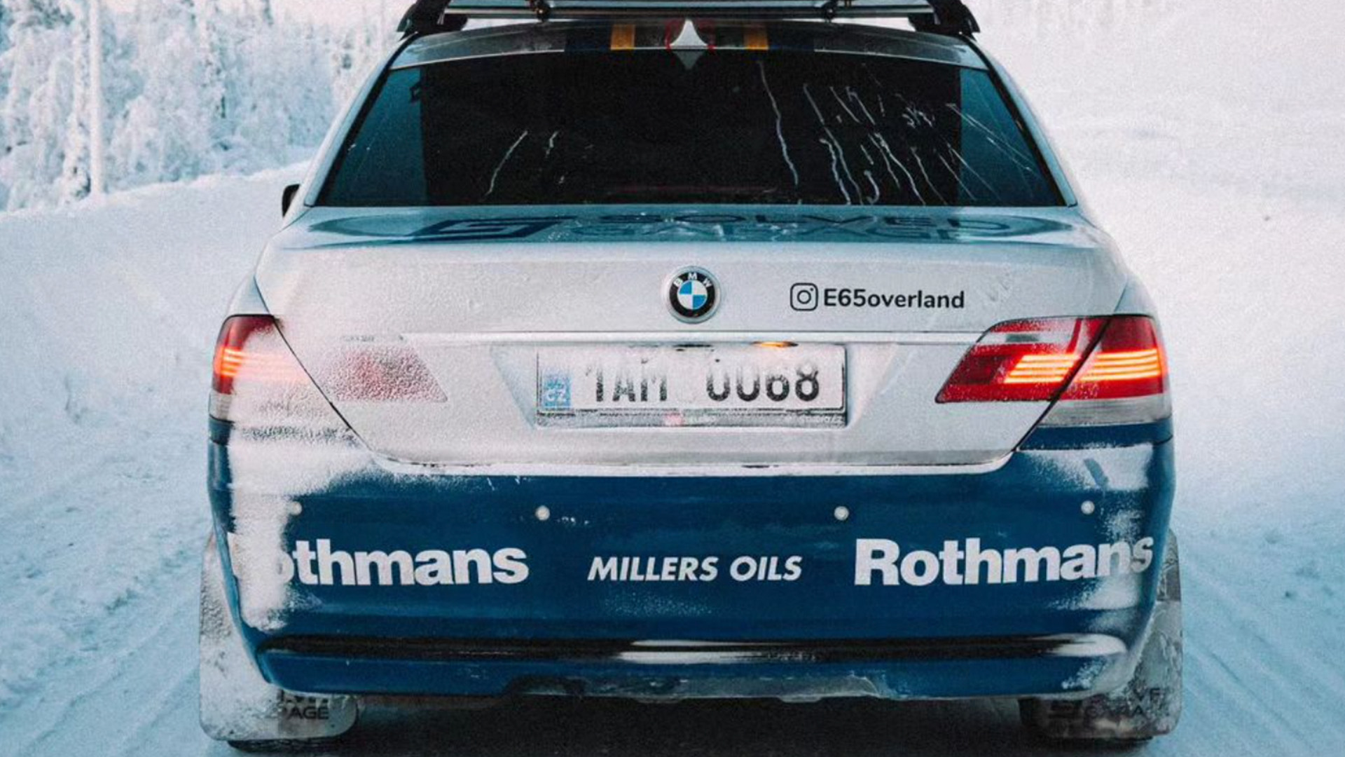 Vista trasera del BMW Serie 7 4x4 cubierto de nieve, mostrando detalle de luces y alerón.