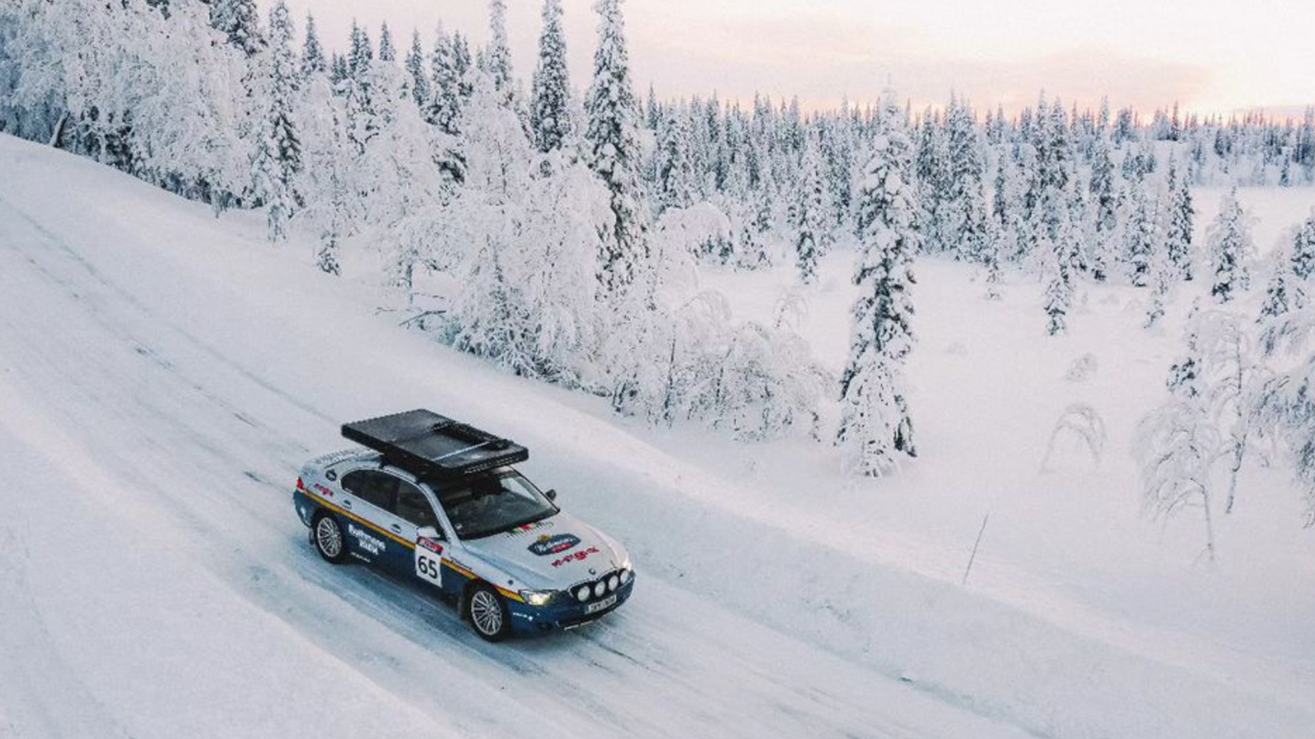 Vista lateral de un BMW Serie 7 habilitado para rally en un entorno nevado.