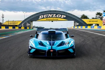 Vista frontal dinámica del Bugatti en Le Mans, enfatizando su aerodinámica.
