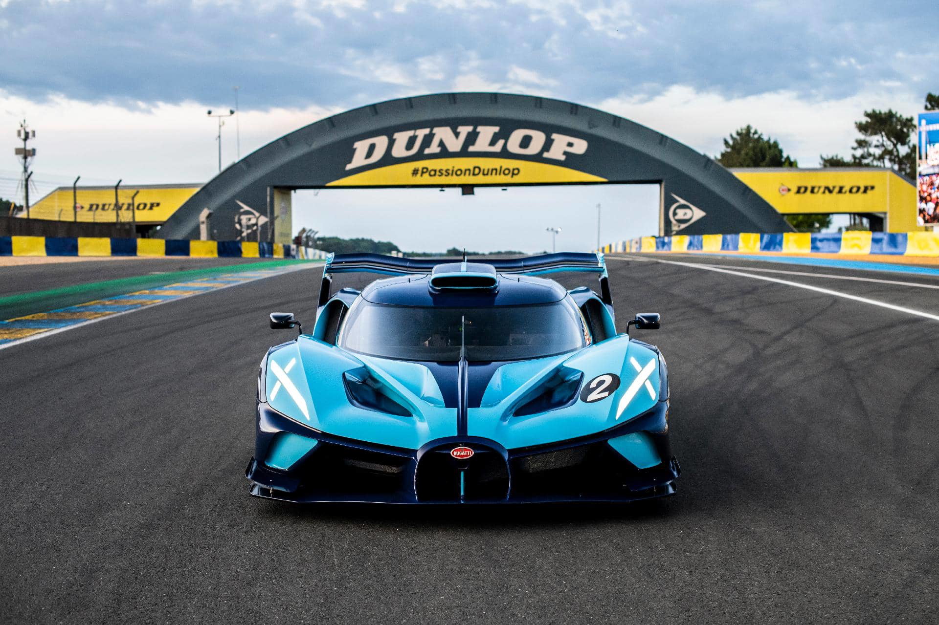Vista frontal dinámica del Bugatti en Le Mans, enfatizando su aerodinámica.