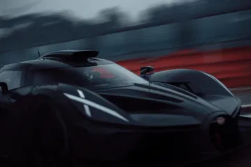 Imagen dinámica del Bugatti en Le Mans, enfocando su aerodinámica delantera y lateral.