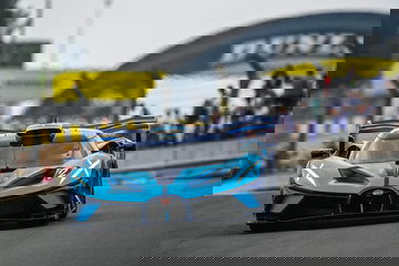 Vista dinámica del Bugatti en competición, destacando su aerodinámica y diseño agresivo.