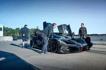 Vista lateral de un Bugatti en preparativos para Le Mans 2024, impresionante diseño y aerodinámica.