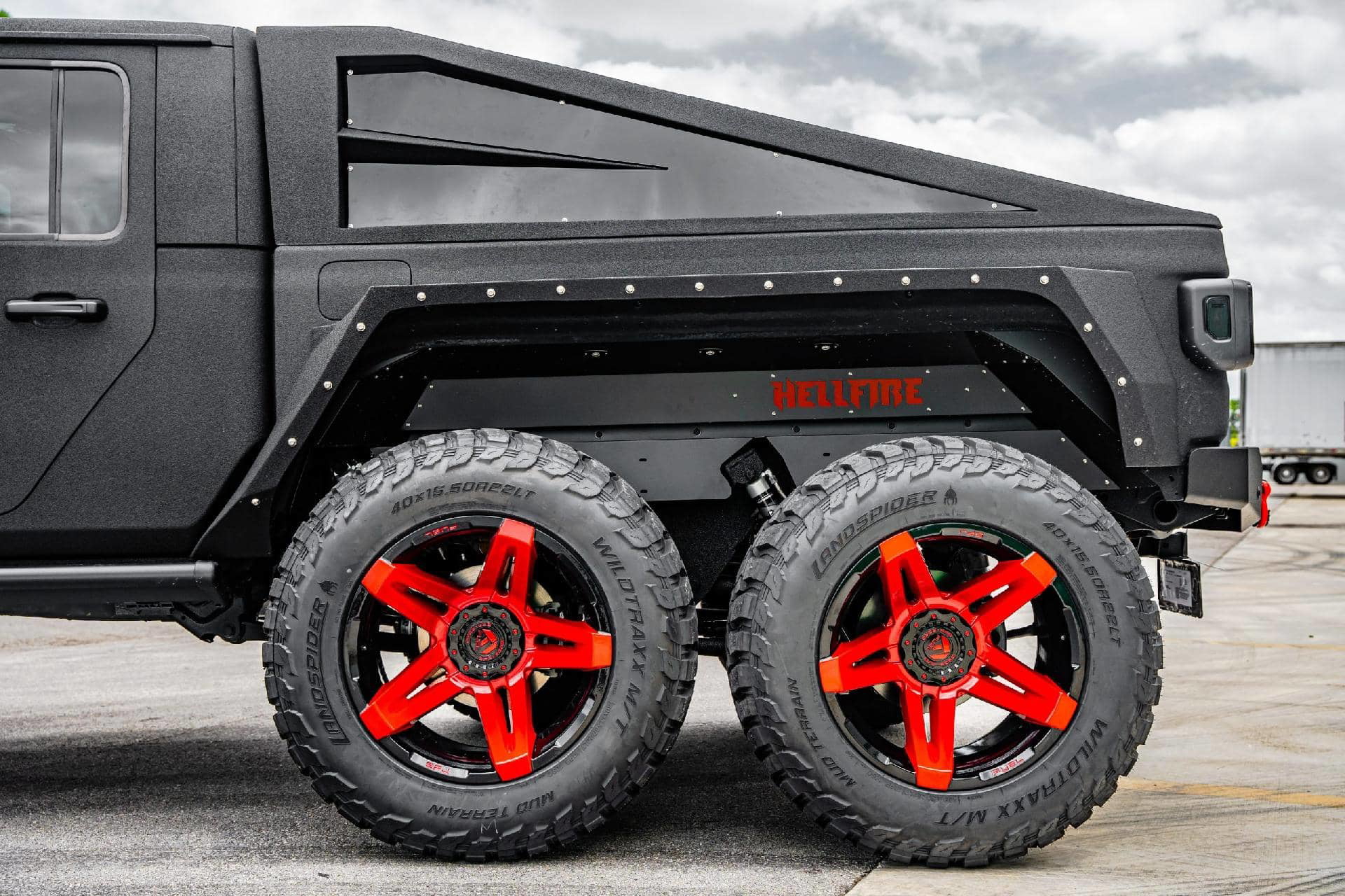 Lateral de camioneta con robustas ruedas marcadas Hellfire.
