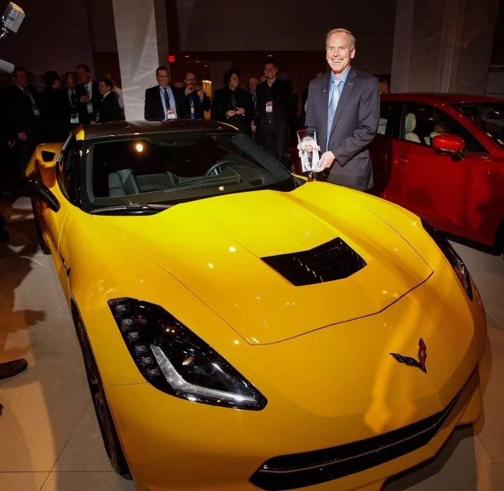 Chevrolet Corvette amarillo recibiendo premio NACTOY en evento automotriz.