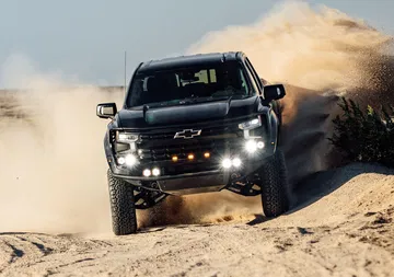 Imponente Chevrolet Silverado abordando terreno agreste con suspensión Fox Factory.
