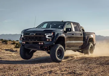 Vista dinámica del Chevrolet Silverado en acción sobre terreno árido.