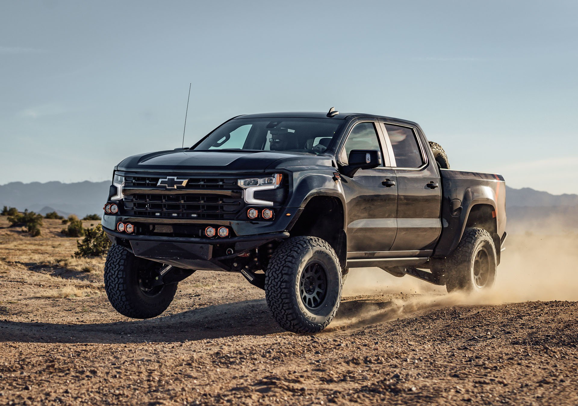 Vista dinámica del Chevrolet Silverado en acción sobre terreno árido.