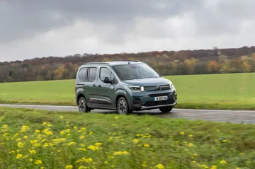 Vista lateral del Citroën Berlingo sobre un entorno campestre.