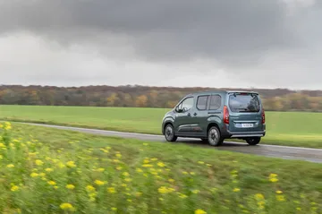 Vista lateral del Citroën Berlingo en un entorno campestre, mostrando su diseño funcional.