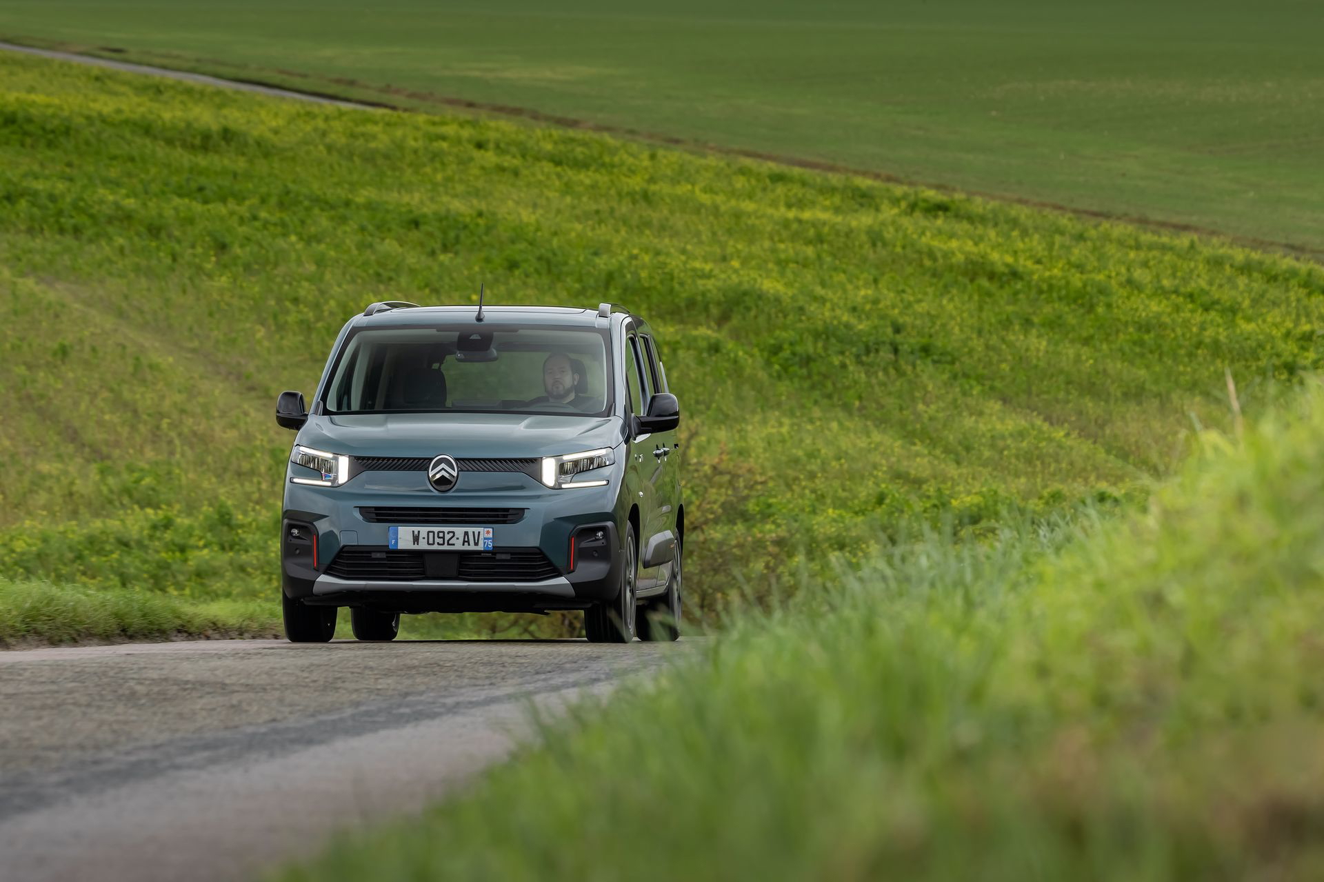 Vista delantera y lateral del Citroën Berlingo en carretera rural.