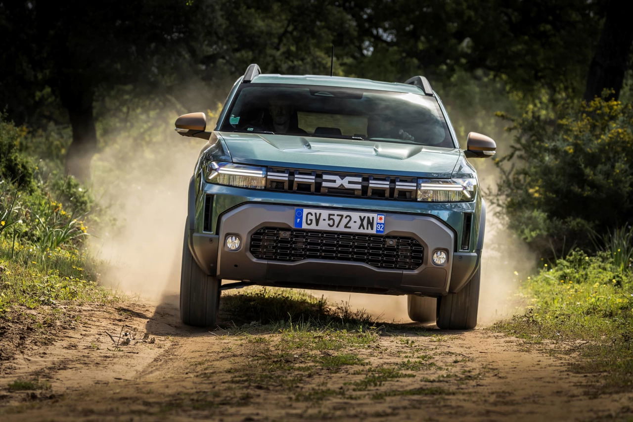 Vista dinámica del Dacia Duster avanzando vigorosamente por un camino de tierra.