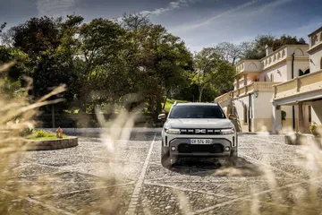Vista dinámica del Dacia Duster atravesando un vado, reflejando su capacidad off-road.