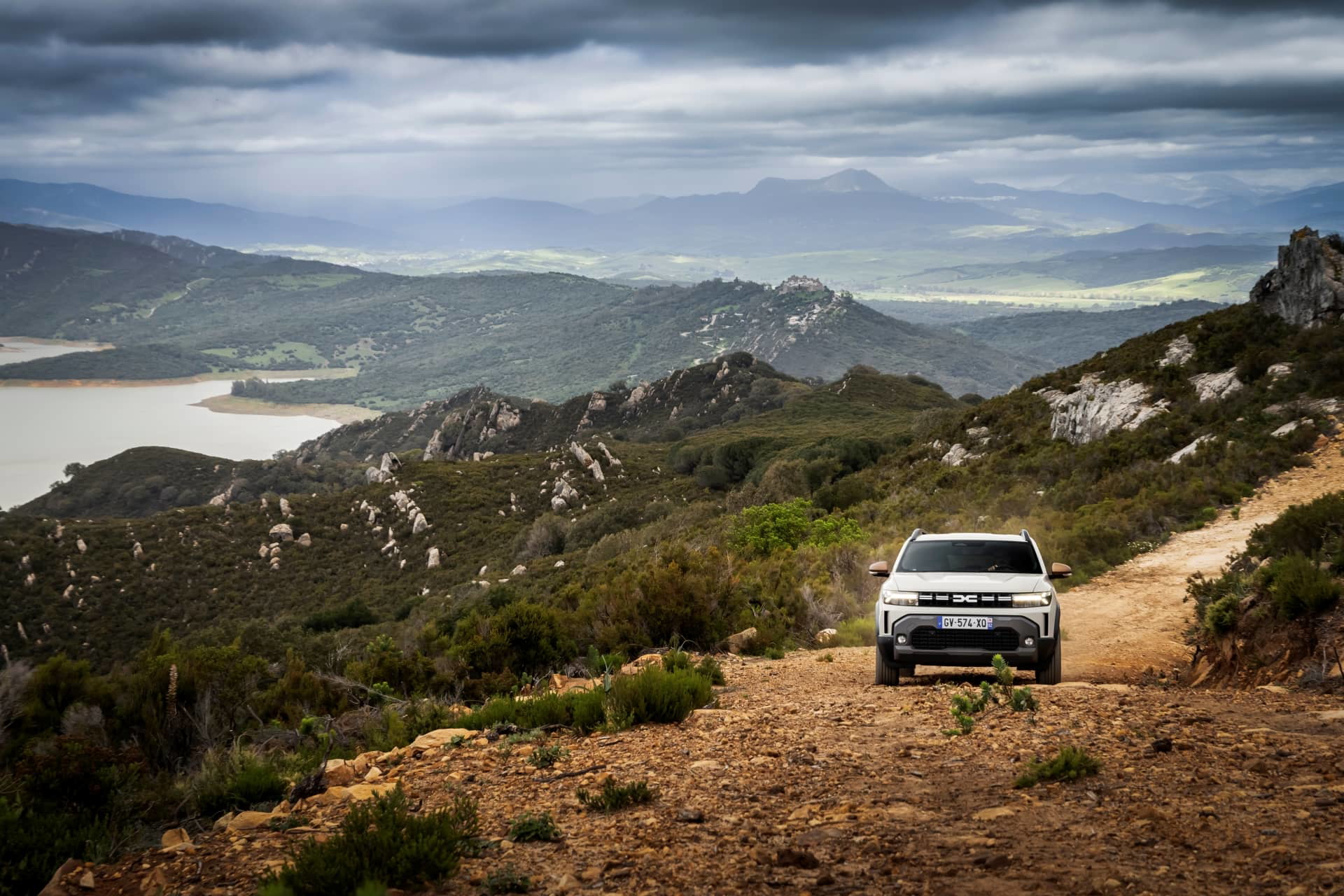 Vista lateral del Dacia Duster en un camino de montaña, realzando su capacidad off-road.