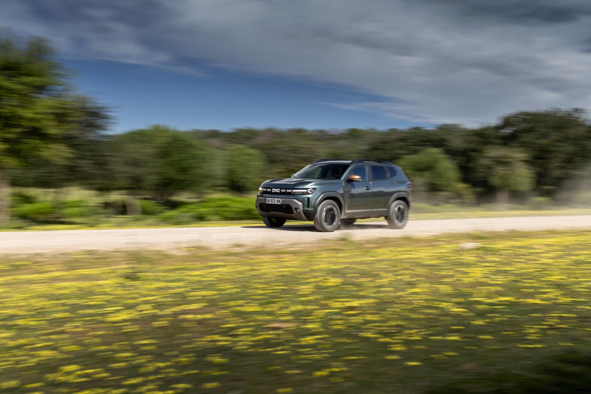 Vista dinámica del Dacia Duster por caminos rurales, destacando su capacidad todoterreno.