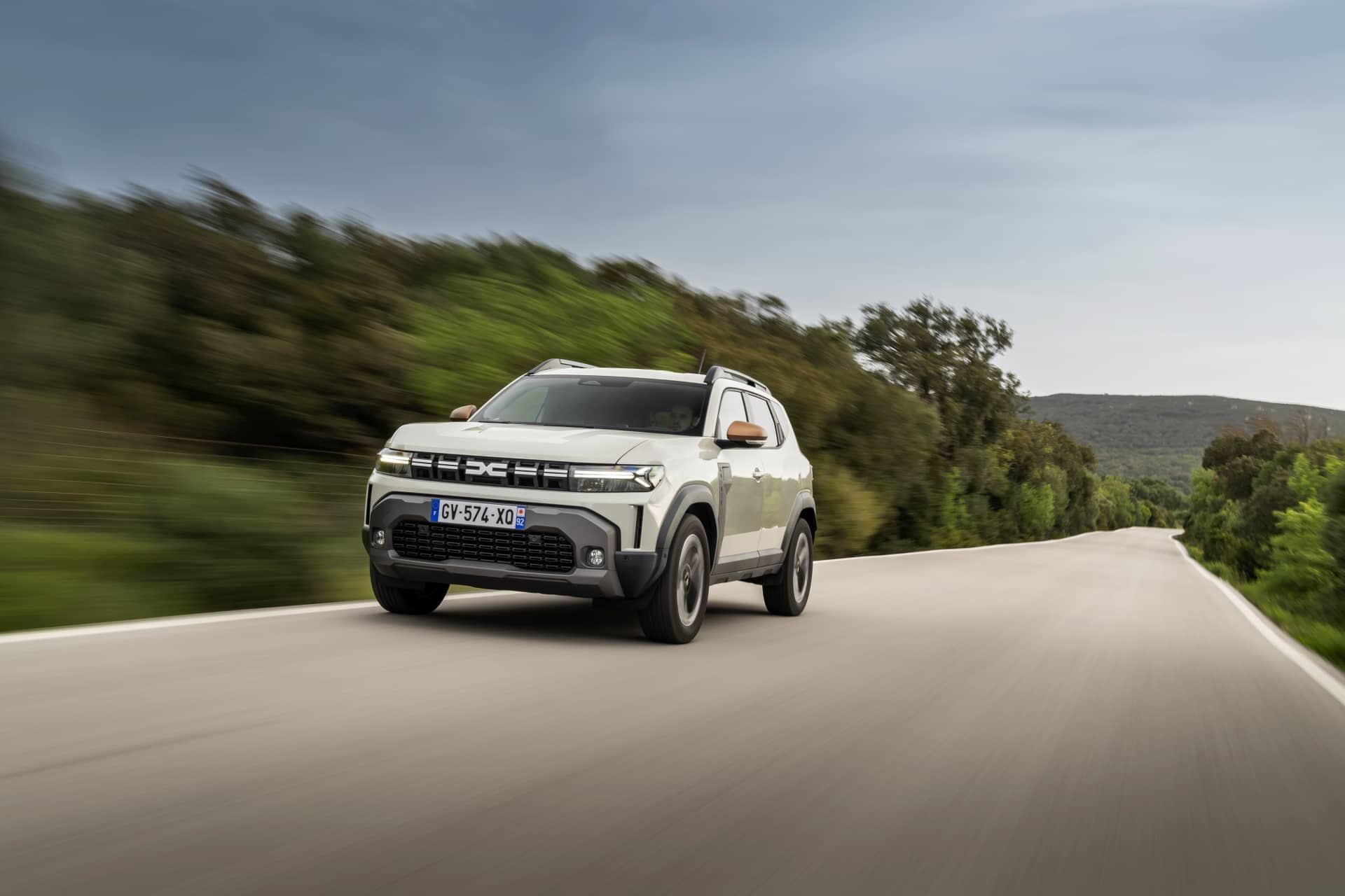 Vista dinámica del Dacia Duster, destacando su frontal robusto y perfil lateral.