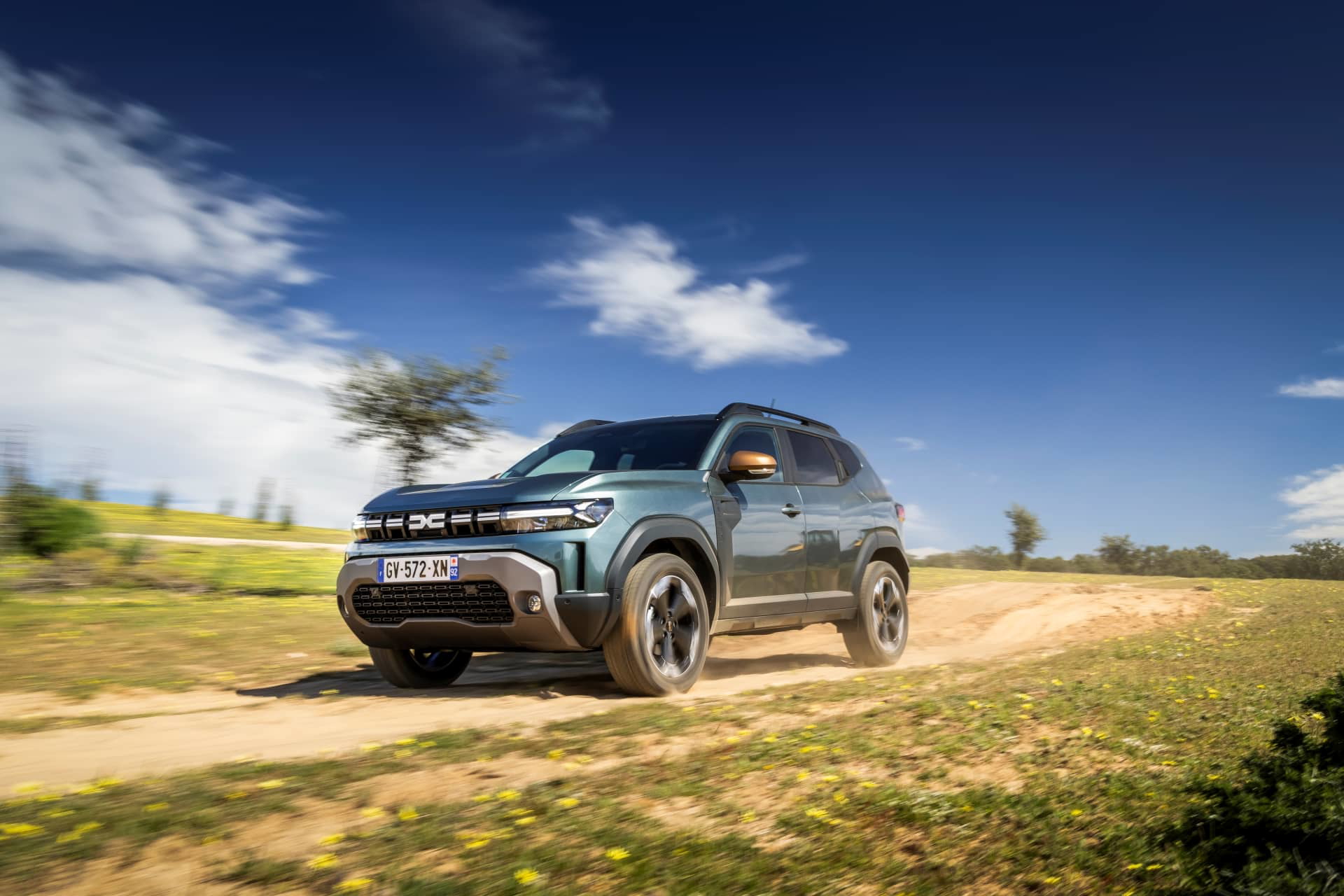 Vista dinámica del Dacia Duster en entorno rural, destacando su porte aventurero.