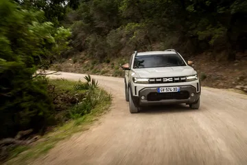 Vista delantera lateral del Dacia Duster en un camino de tierra