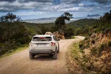 Vista trasera y lateral del Dacia Duster en camino rural