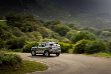 Vista lateral del Dacia Duster en un ambiente de montaña, realzando su carácter SUV.