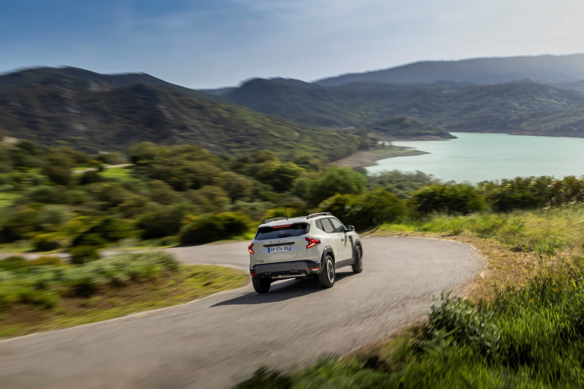 Vista dinámica del Dacia Duster transitando por una ruta escénica.