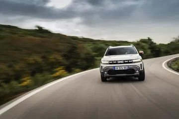 Vista frontal del Dacia Duster en carretera, realzando su aspecto robusto y aventurero.