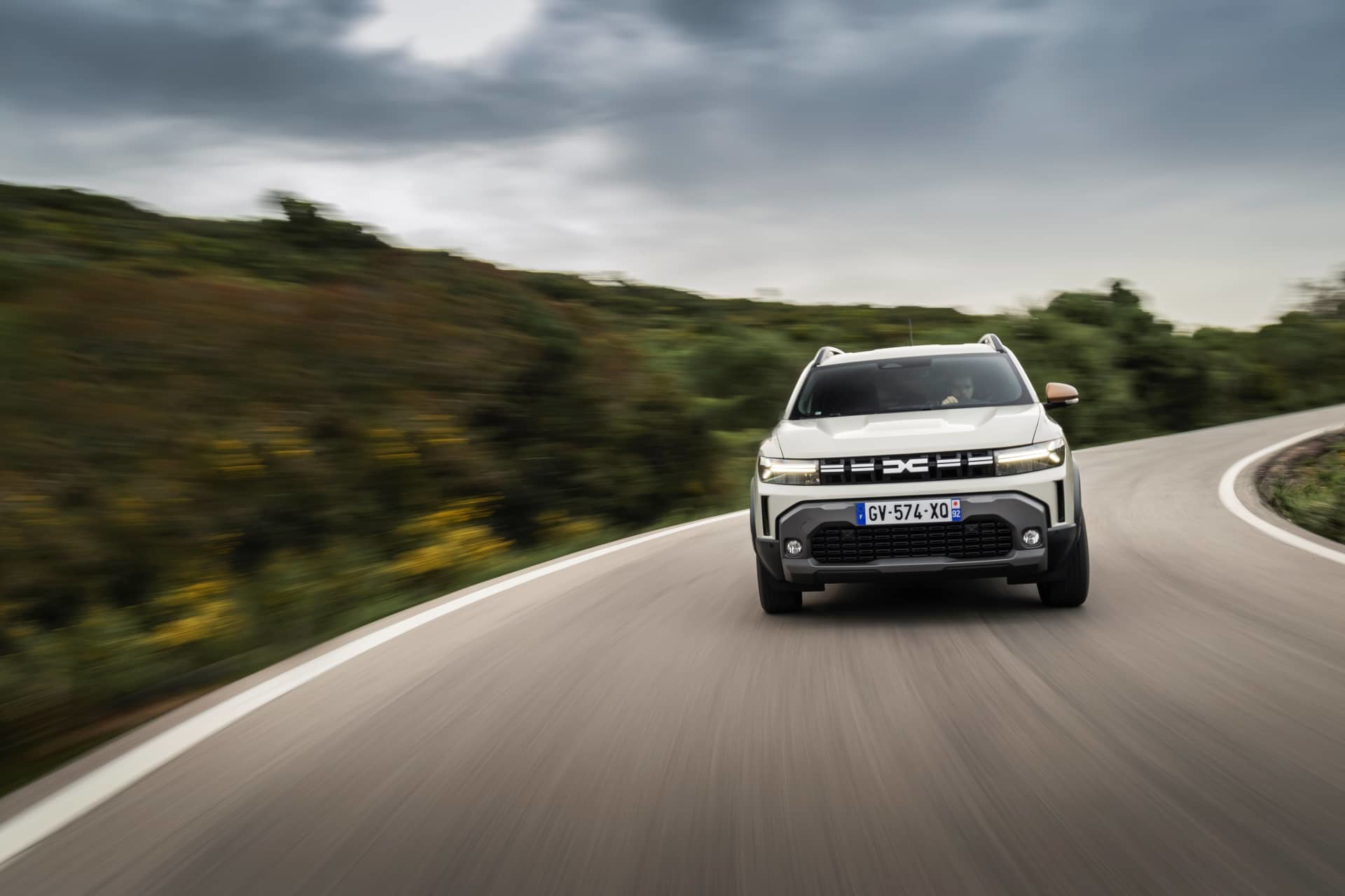 Vista frontal del Dacia Duster en carretera, realzando su aspecto robusto y aventurero.