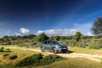 Vista angular del Dacia Duster en un entorno natural, destacando su enfoque aventurero.