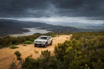 Vista lateral y frontal del Dacia Duster en un paisaje natural.