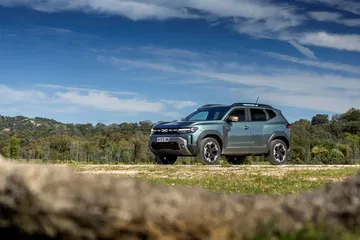 Vista lateral del Dacia Duster en entorno natural, destacando su perfil aventurero.