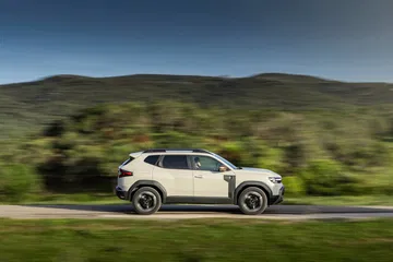 Vista lateral del Dacia Duster en ambiente natural demostrando su perfil robusto.