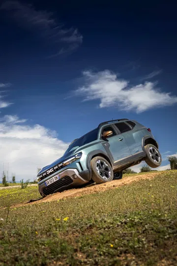Vista dinámica lateral del Dacia Duster mostrando su perfil robusto y aventurero.