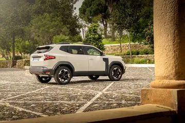 Vista lateral del Dacia Duster destacando su línea y diseño robusto.