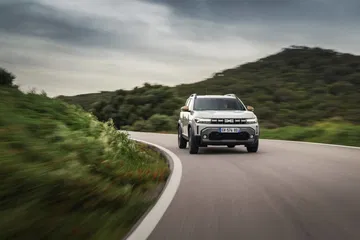 Vista dinámica del Dacia Duster en carretera, destacando su diseño frontal.