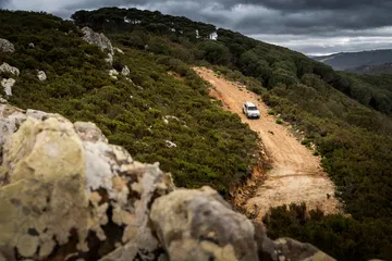 Vista lateral del Dacia Duster atravesando un camino montañoso.