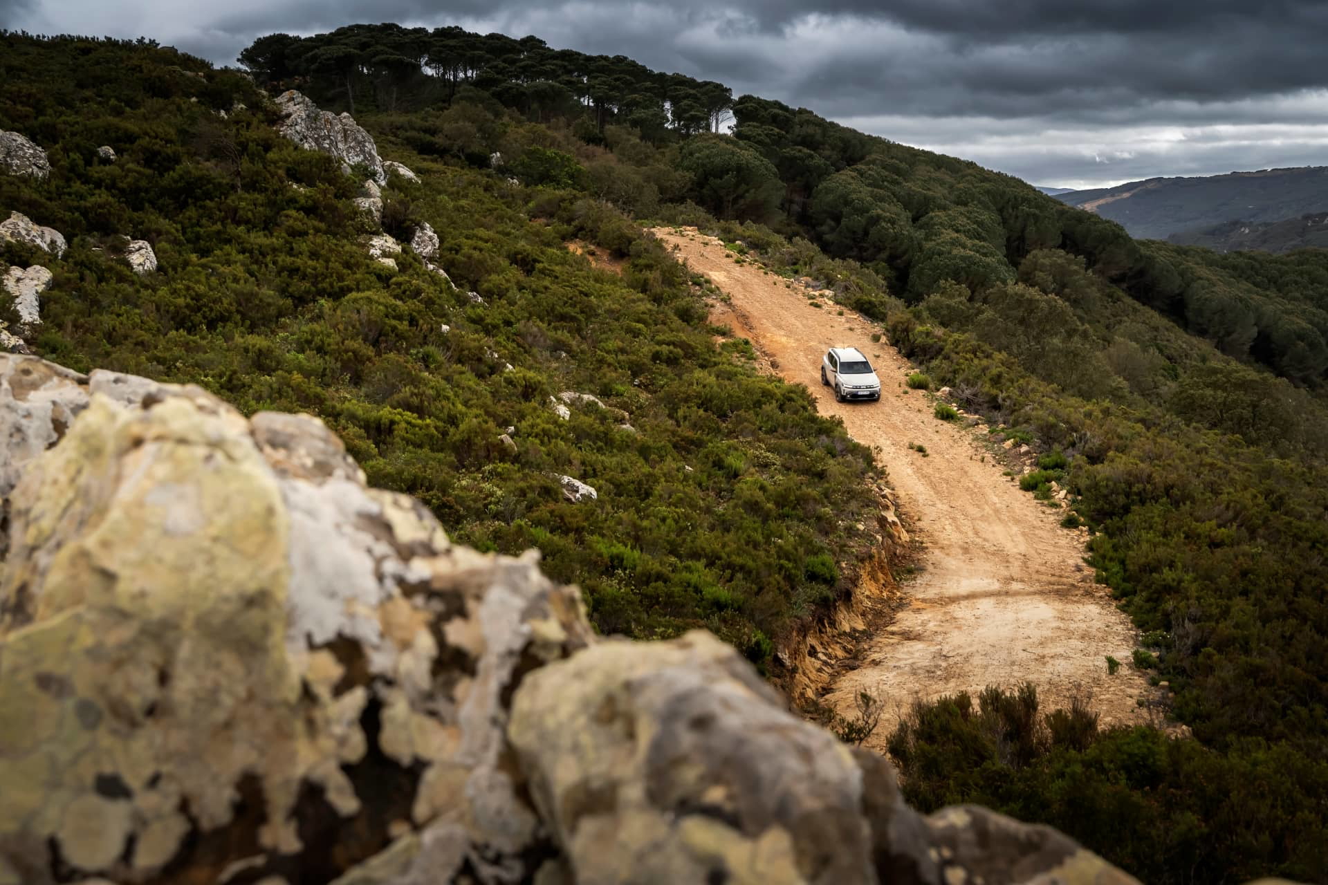 Vista lateral del Dacia Duster atravesando un camino montañoso.