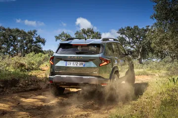 Vista dinámica del Dacia Duster superando terreno irregular con destreza