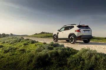 Vista lateral del Dacia Duster destacando su silueta robusta en entorno natural.