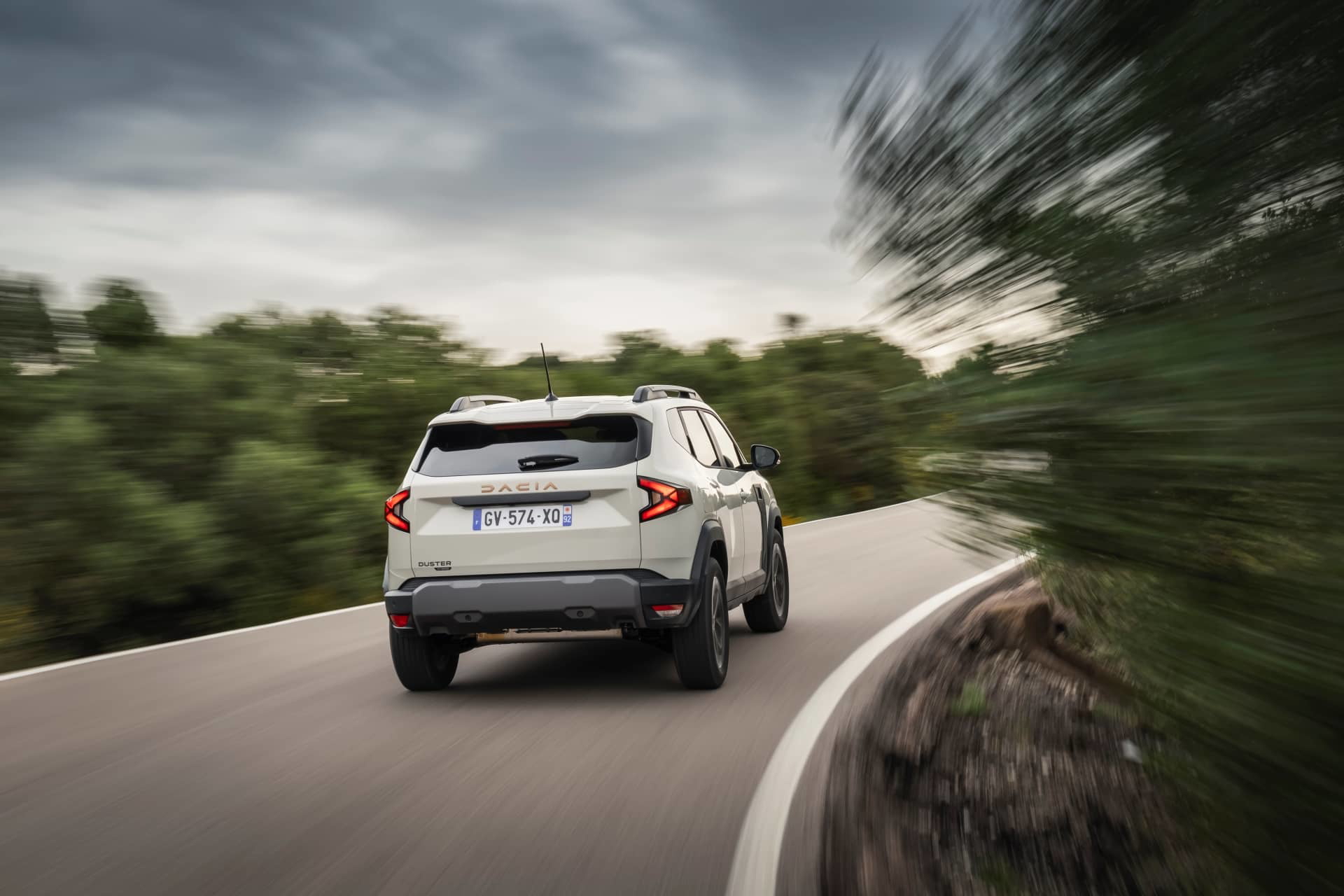 Vista dinámica de la parte trasera y lateral del Dacia Duster en movimiento.