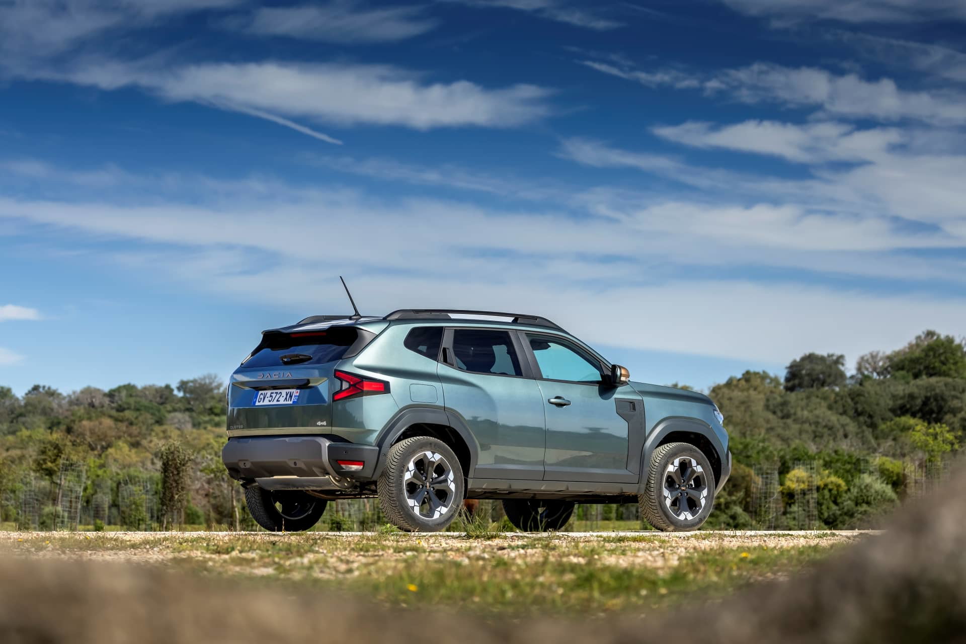 Dacia Duster capturado en una ruta, destacando su perfil lateral robusto y dinámico.