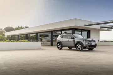 Vista lateral del Dacia Duster resaltando su diseño robusto y líneas aerodinámicas.
