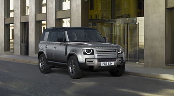 Vista angular del Land Rover Defender en un entorno urbano, destacando su robusta presencia.