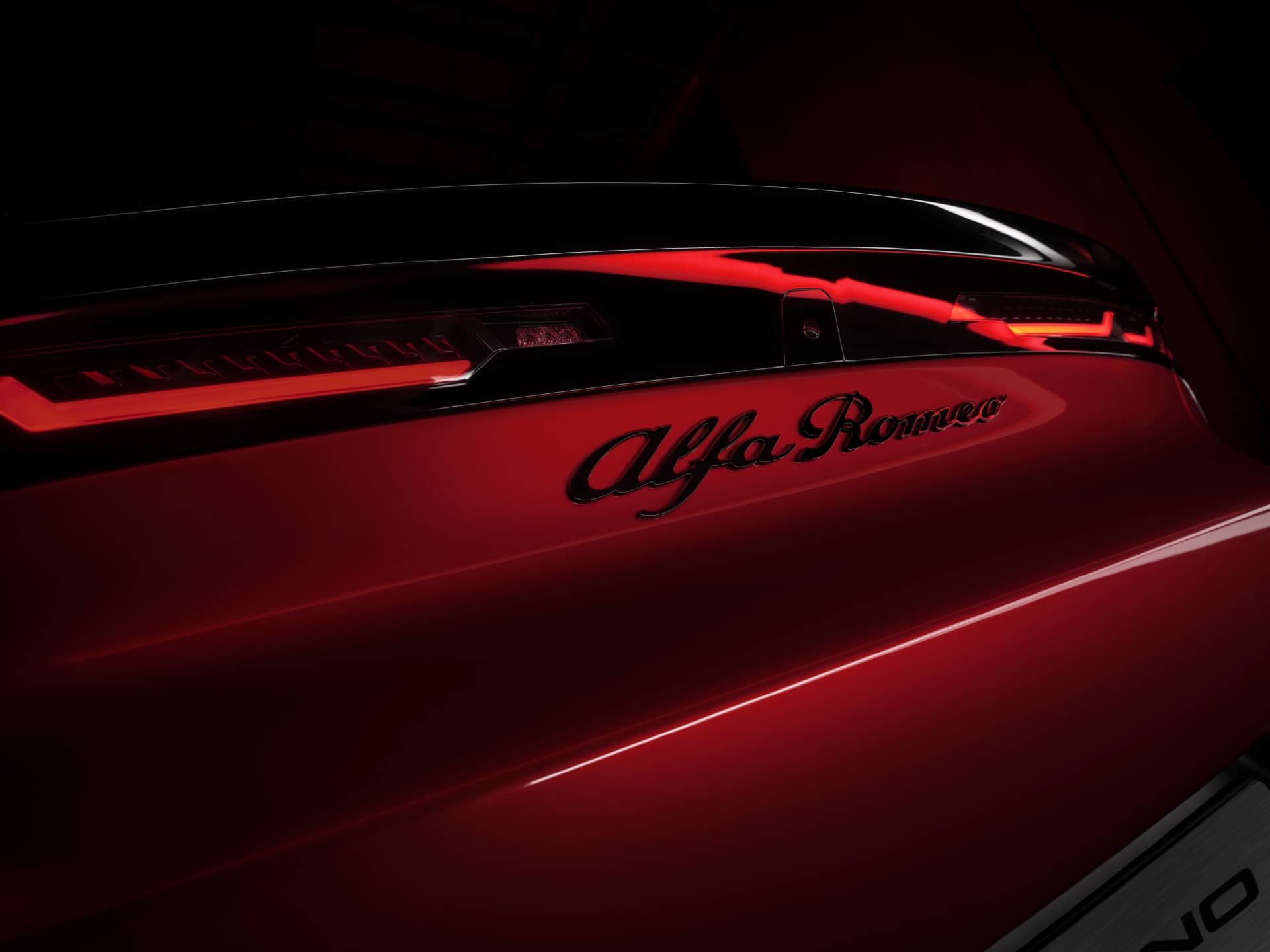 Vista parcial logotipo Alfa Romeo Junior en carrocería roja.