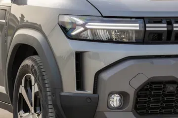 Visión cercana de la óptica y el diseño lateral del Dacia Duster.