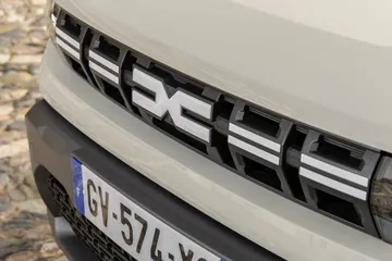 Vista cercana de la parrilla frontal del Dacia Duster, destacando su diseño característico.